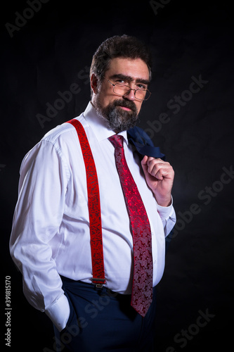 Mature businessman dressed in blue suit with red tie studio portrait.