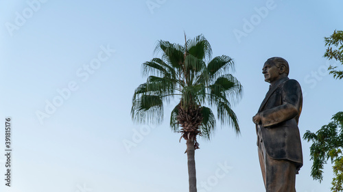 Atatürk statue with palm and blue sky in the background. side in antalya turkey