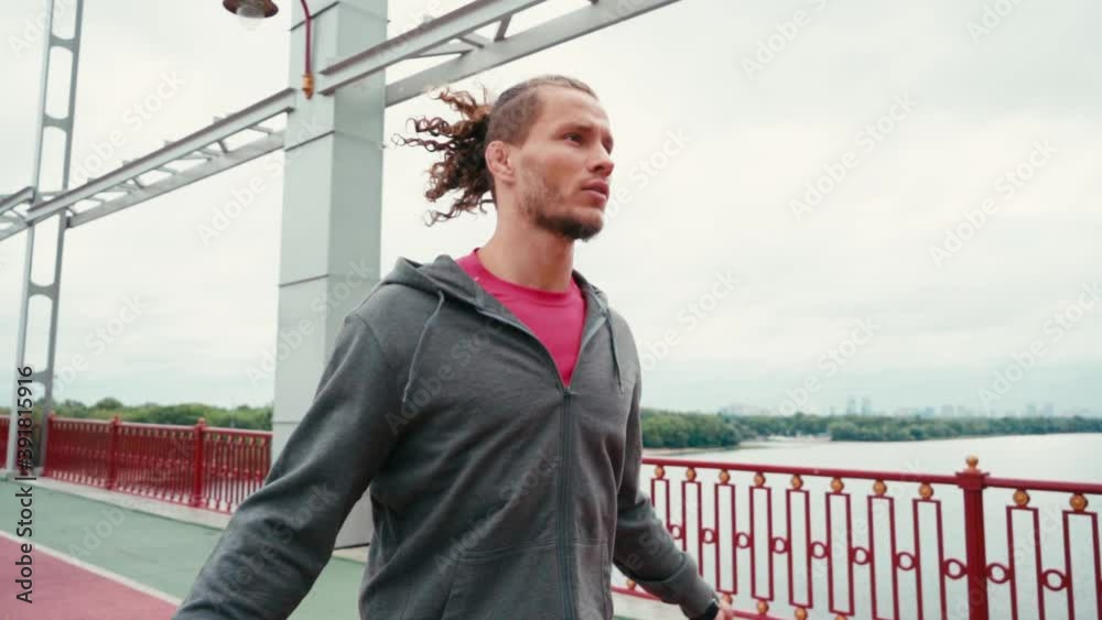 Focused sportsman rope jumping on bridge with nature landscape on background Focused sportsman rope jumping on bridge with nature landscape on background