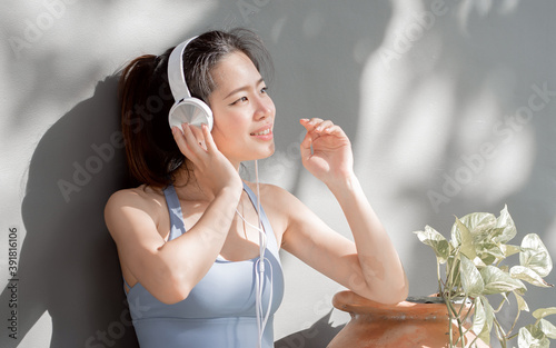 Asian healthy woman wearing sport bra and listen music