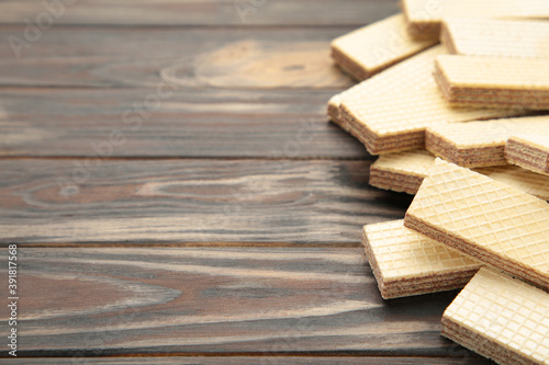 Sweet wafers on brown wooden background  top view.
