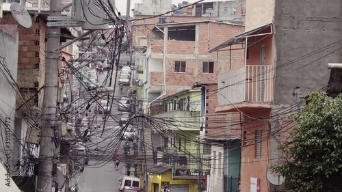 Establishing shot of one of the largest slums of Latin America. In the scene brick houses in a narrow street covered with power cables in a poor suburban neighbourhood. photo