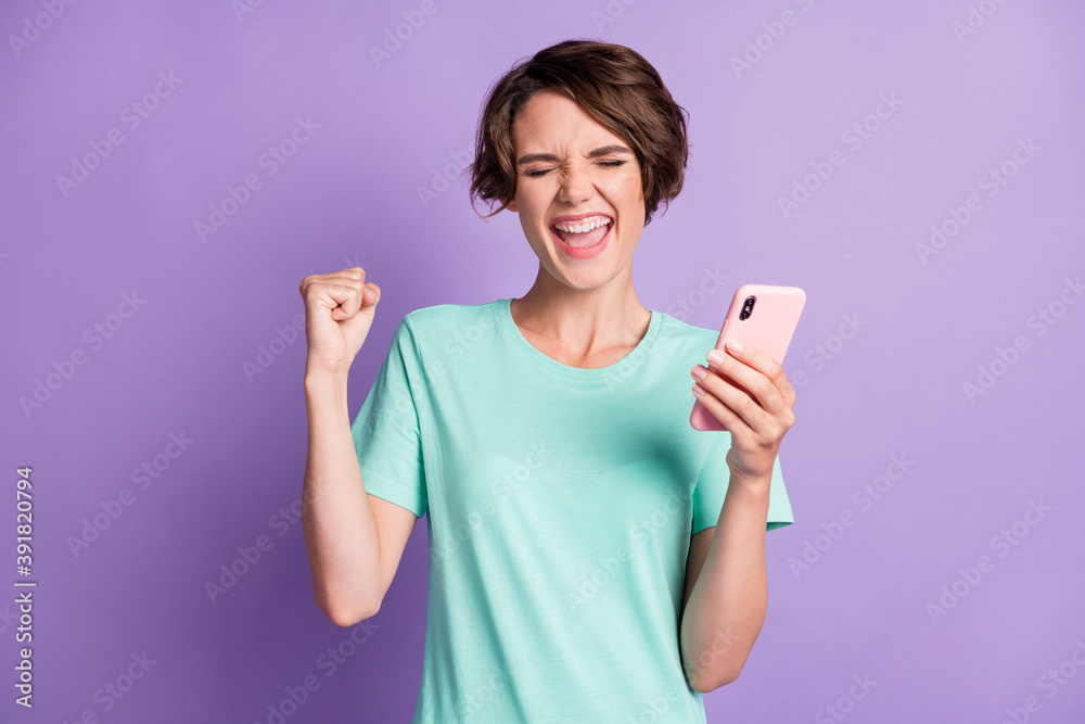 Portrait of attractive positive lady closed eyes scream fist up open mouth teal outfit isolated on purple color background Portrait of attractive positive lady closed eyes scream fist up open mouth teal outfit isolated on purple color background