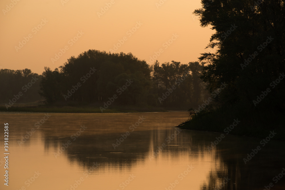 a soft orange sunrise over a calm lake overgrown with water lilies a soft orange sunrise over a calm lake overgrown with water lilies