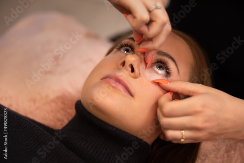 Eyelash extension procedure with clinic master and a client in a beauty salon