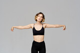 Sporty woman in leggings on a gray background is engaged in fitness Copy Space