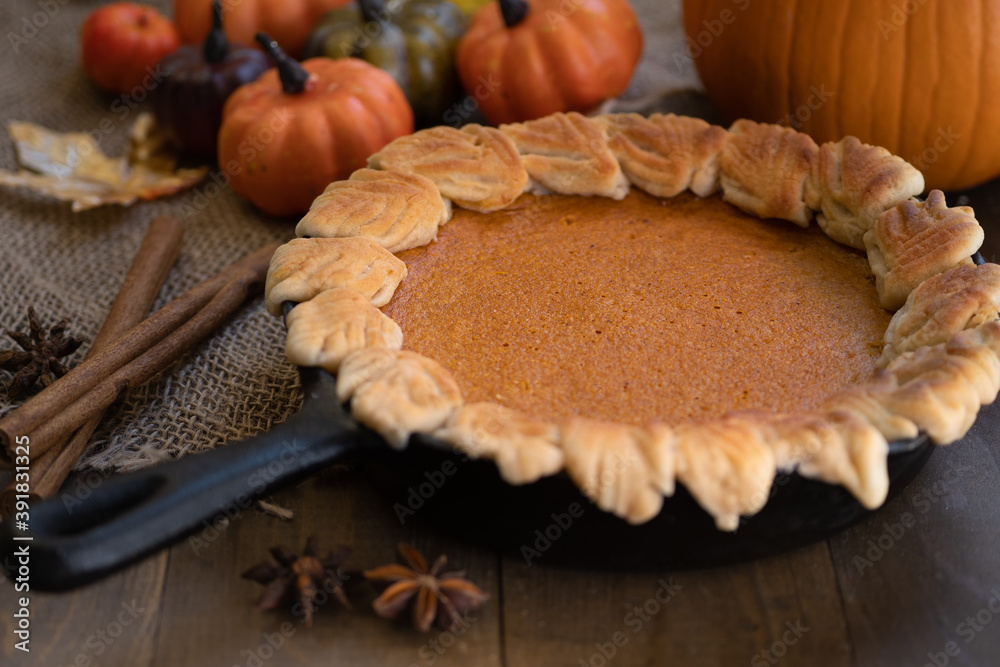 Homemade pumpkin pie baked in cast iron pan, on wooden background Homemade pumpkin pie baked in cast iron pan, on wooden background