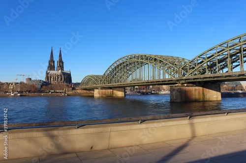 The Hohenzollern bridge over Rhine river on a sunny day. The Cologne Cathedral (Kolner Dom) in the city of Cologne, Germany. It is the largest Gothic church in northern Europe. photo