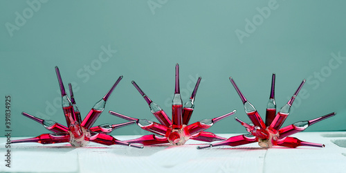 Glass ampoules with a red medicine vitamine b12 coronavirus vaccine glued together  