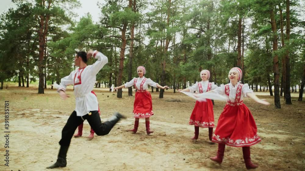 Dancing group are dancing Russian Traditional dances in summer forest Dancing group are dancing Russian Traditional dances in summer forest