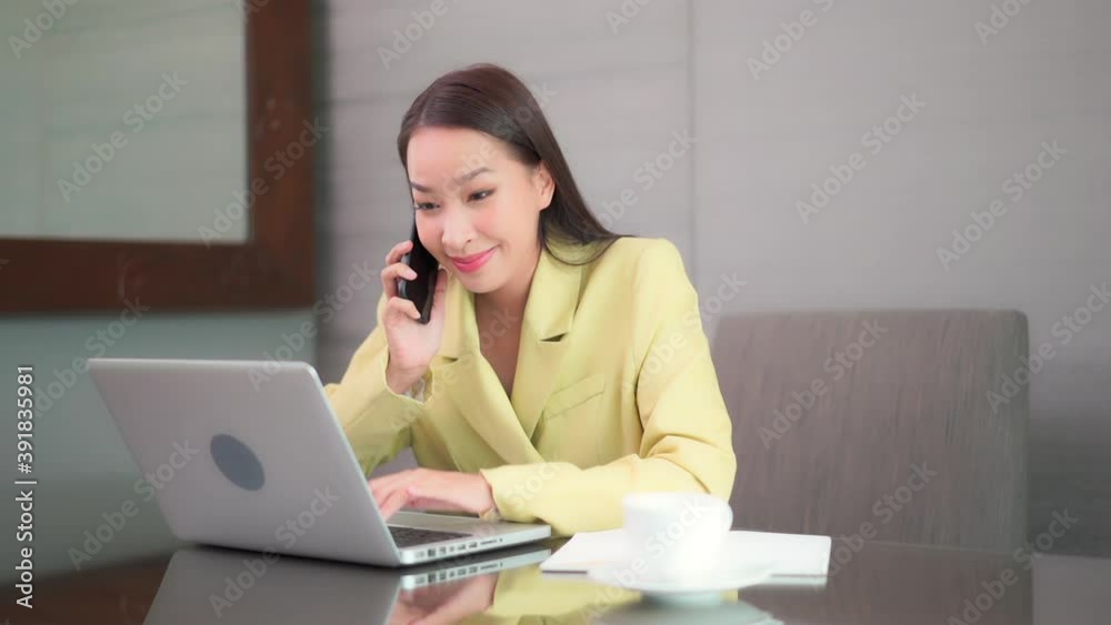 Successful young Asian girl in a modern office in yellow suite Successful young Asian girl in a modern office in yellow suite