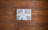 Silver gift with winter print on dark wooden background