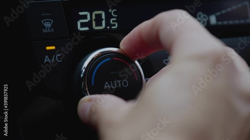 set up air conditioner in the car. Hand turns air conditioner ring. Display indicates temperature inside the car. Cooling air in the car