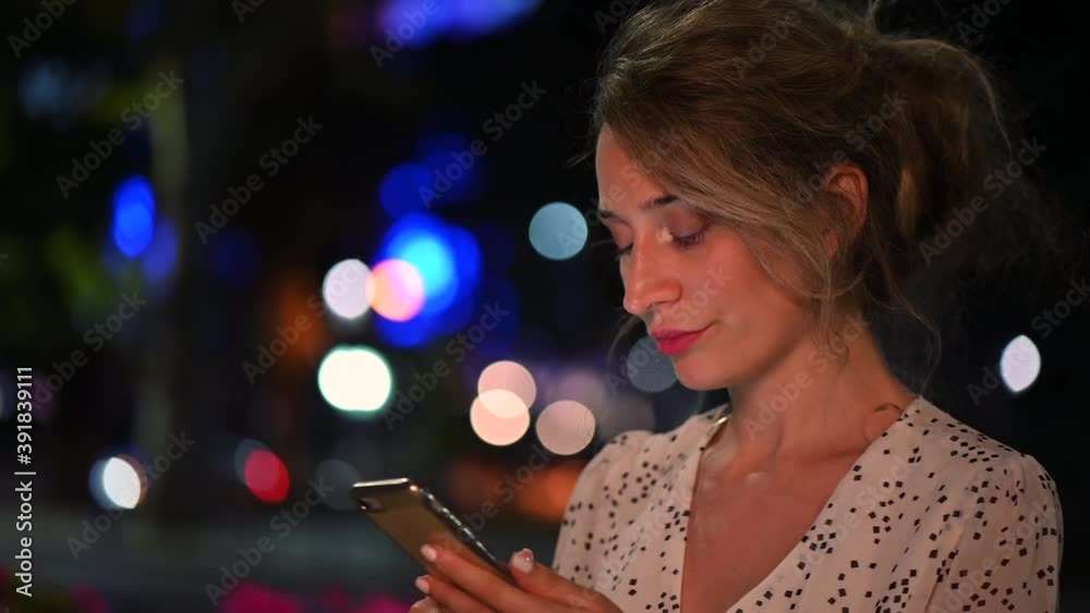 Woman wearing white dress working and talking on mobile phone at night Woman wearing white dress working and talking on mobile phone at night