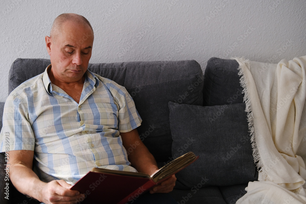 an elderly man looks through an album with old photographs, a concept of memories of youth, childhood, remembering his life, relatives, family connection of generations an elderly man looks through an album with old photographs, a concept of memories of youth, childhood, remembering his life, relatives, family connection of generations