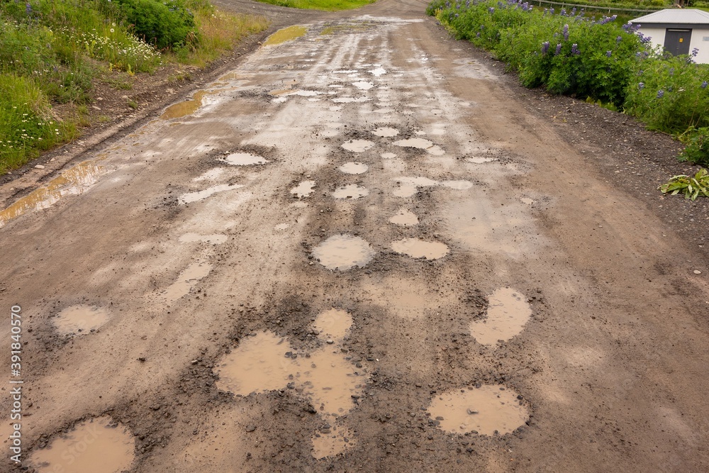 Potholes with water puddles on Icelandic muddy gravel roads Potholes with water puddles on Icelandic muddy gravel roads