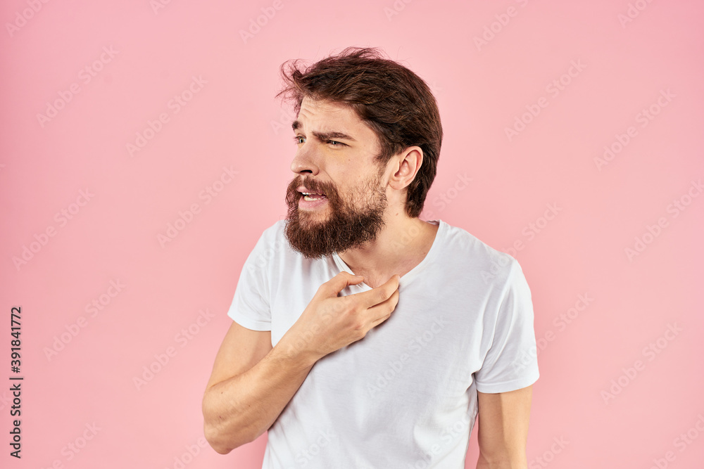 Man in white t-shirt gestures with hands emotions lifestyle cropped view pink background
