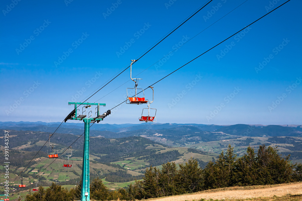Obraz Empty mountain ski chairlift in summer. Forest mountains panorama on the horizon. Travel concept.