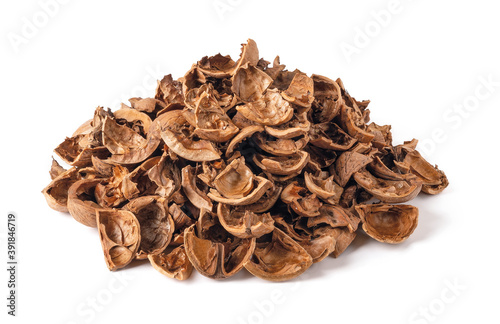 Pile of empty broken walnut shells isolated on white background. Biodegradable food waste and peelings. Nut crop concept.