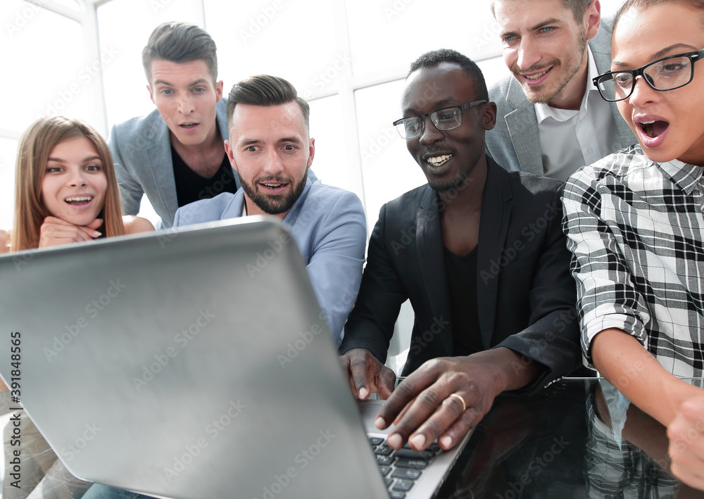 Obraz premium young colleagues looking at laptop with smile on face