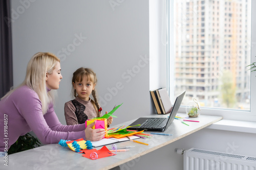 Mother with child girl drawing and cutting together