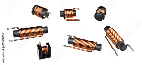 Set of solenoid coils with black ferrite core isolated on white background. Close-up of cylindric inductors with helical copper wire winding. Group of electronic components. Electromagnetic induction. photo