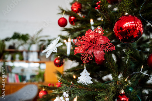 red balls on the Christmas tree, decoration of the Christmas tree with flowers and toys of red color, new year's interior