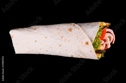 Delicious turkish doner kebab with shrimps, tomatoes, lettuce, parsley, cucumbers and sauce isolated on black background	