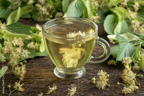 A cup of herbal tea with linden flowers and leaves