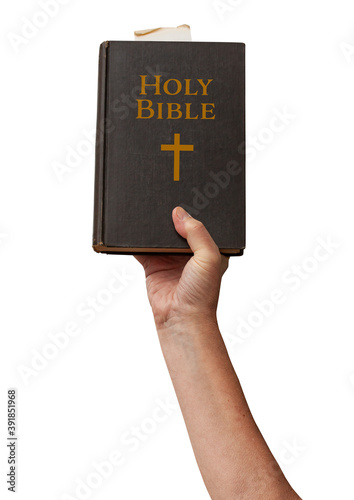 Naked arm raised into the air with hand reaching up holding the Holy Bible book of Chistianity with golden title on binding. Symbolic posture of prayer and worship. Isolated on white background.
