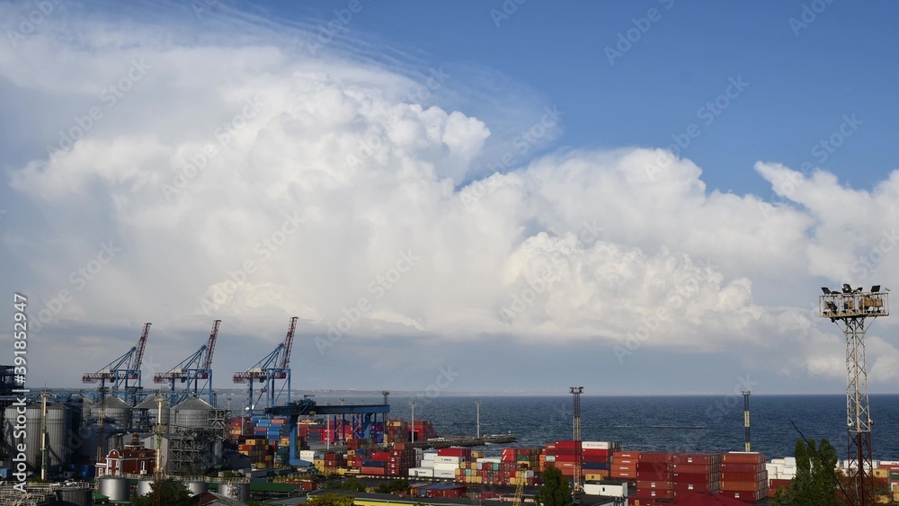 White clouds forming over industrial port skyline