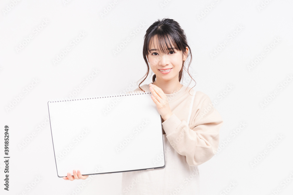 大きいスケッチブックを持つ若い女性 大きいスケッチブックを持つ若い女性