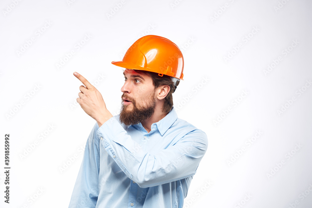 Man in orange hard hat industry engineer work professional light background Man in orange hard hat industry engineer work professional light background