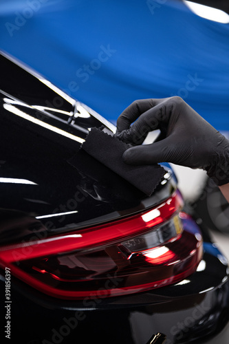 Car detailing studio worker applying car ceramic coating