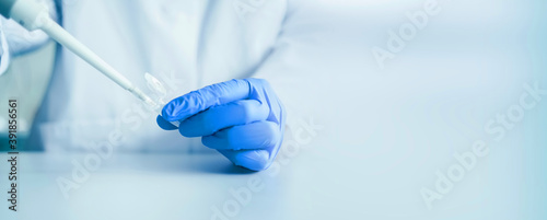 Hands of a scientist who works with pipette and a test tube. Research technician in the genetic laboratory. medical and research banner