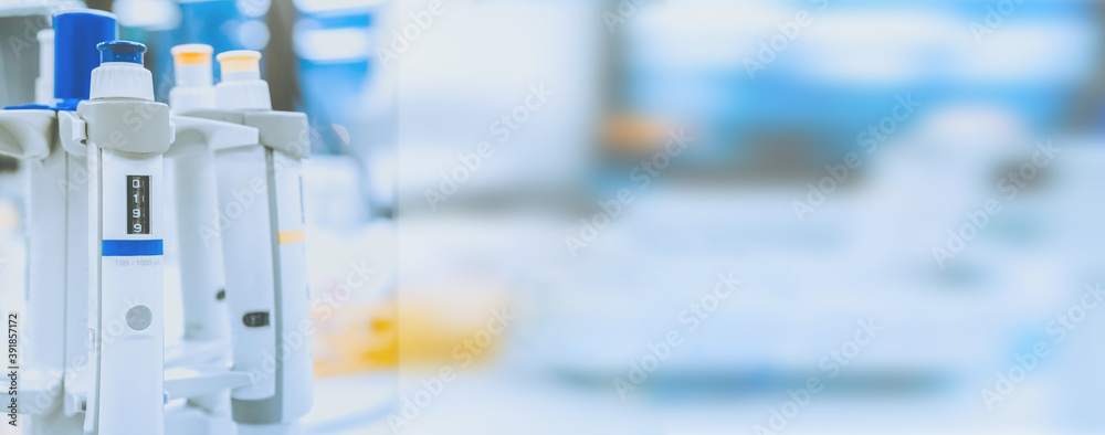 medical and research banner. Laboratory pipettes on blurred laboratory background. Research and development concept with free space for text. medical and research banner. Laboratory pipettes on blurred laboratory background. Research and development concept with free space for text.