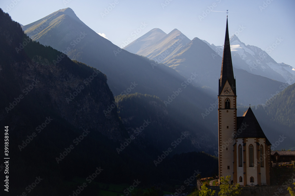 The parish church in Heiligenblut with the Grossglockner in the background in late evening sun