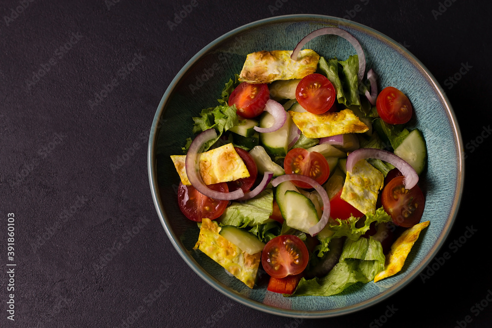 Traditional Arabic fattoush salad on a plate on the table.