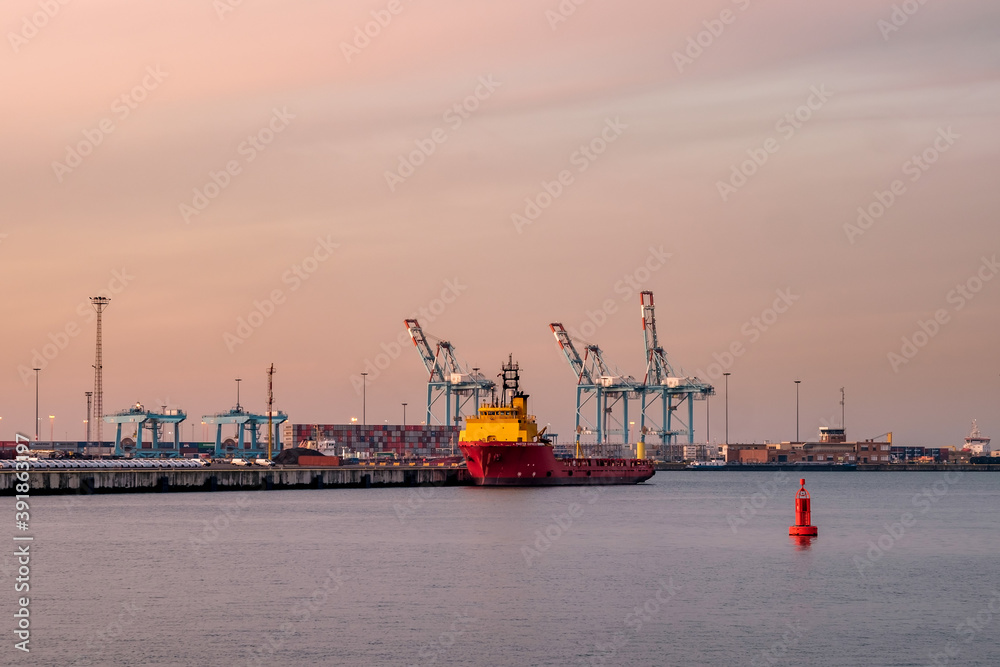 Container terminal in the port of Zeebrugge at sunset. View from the viewing platform near the monument 