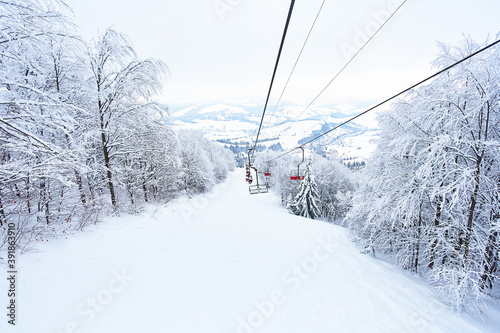 Cable car in a beautiful forest after a snowfall. Landscape with clouds, fog and forest