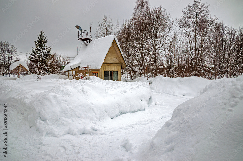 Real, Russian winter, when frost and a lot of snow, in the country village, with small houses, roads through high snowdrifts