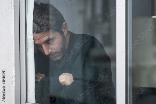Obraz na plátně dramatic portrait of attractive sad and depressed mid adult man looking through