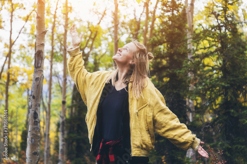 Attractive young Caucasian woman having fun time walking in the forest. Dancing at the sunlight on Autumn day. Concept about lifestyle, people and nature. © MayR