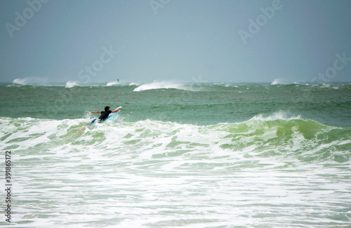 A surfer braves the high surf during tropical storm ETA on St. Pete Beach, Florida