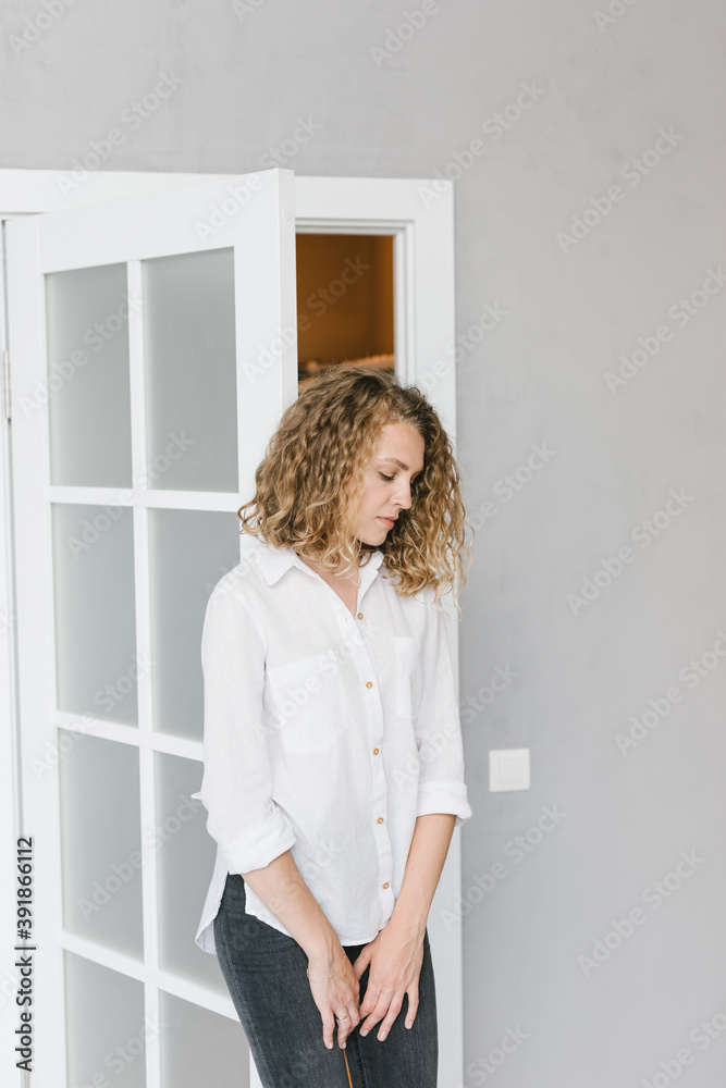 Portrait of a beautiful blonde in a white shirt on a gray background Portrait of a beautiful blonde in a white shirt on a gray background