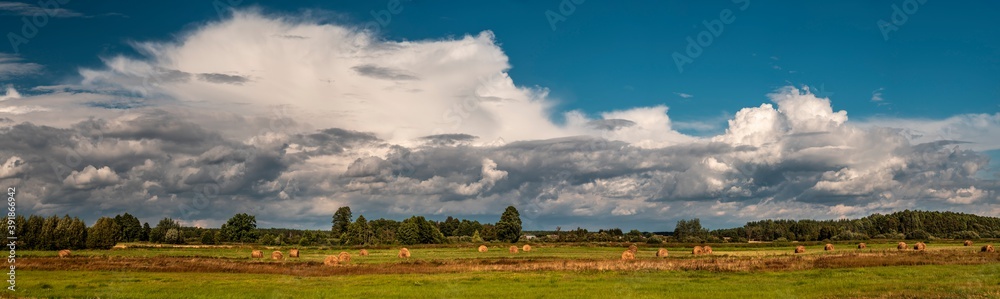 Dramatic view of a cloud over a field, horizontal cloud formation, panorama view.