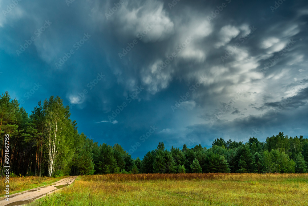 Dramatic view of a cloud over a field, horizontal cloud formation, panorama view.