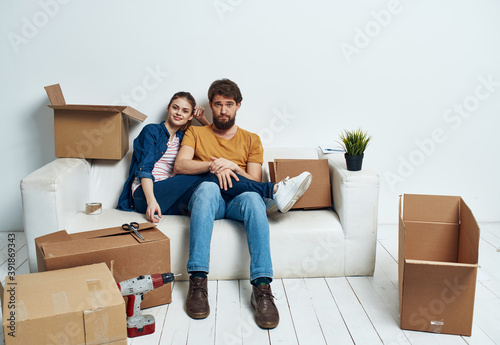 man and woman on the couch moving boxes renovation work leisure interior room