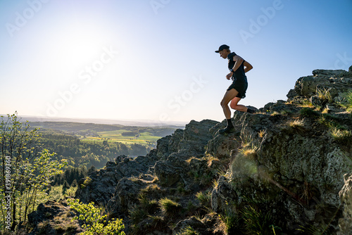 Trail Runner runs down the rocky mountains © Pavel
