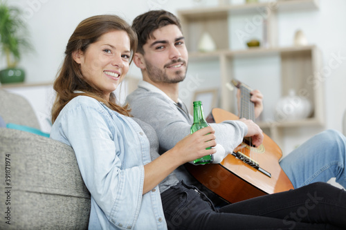 romantic couple at home playing guitar in their living room